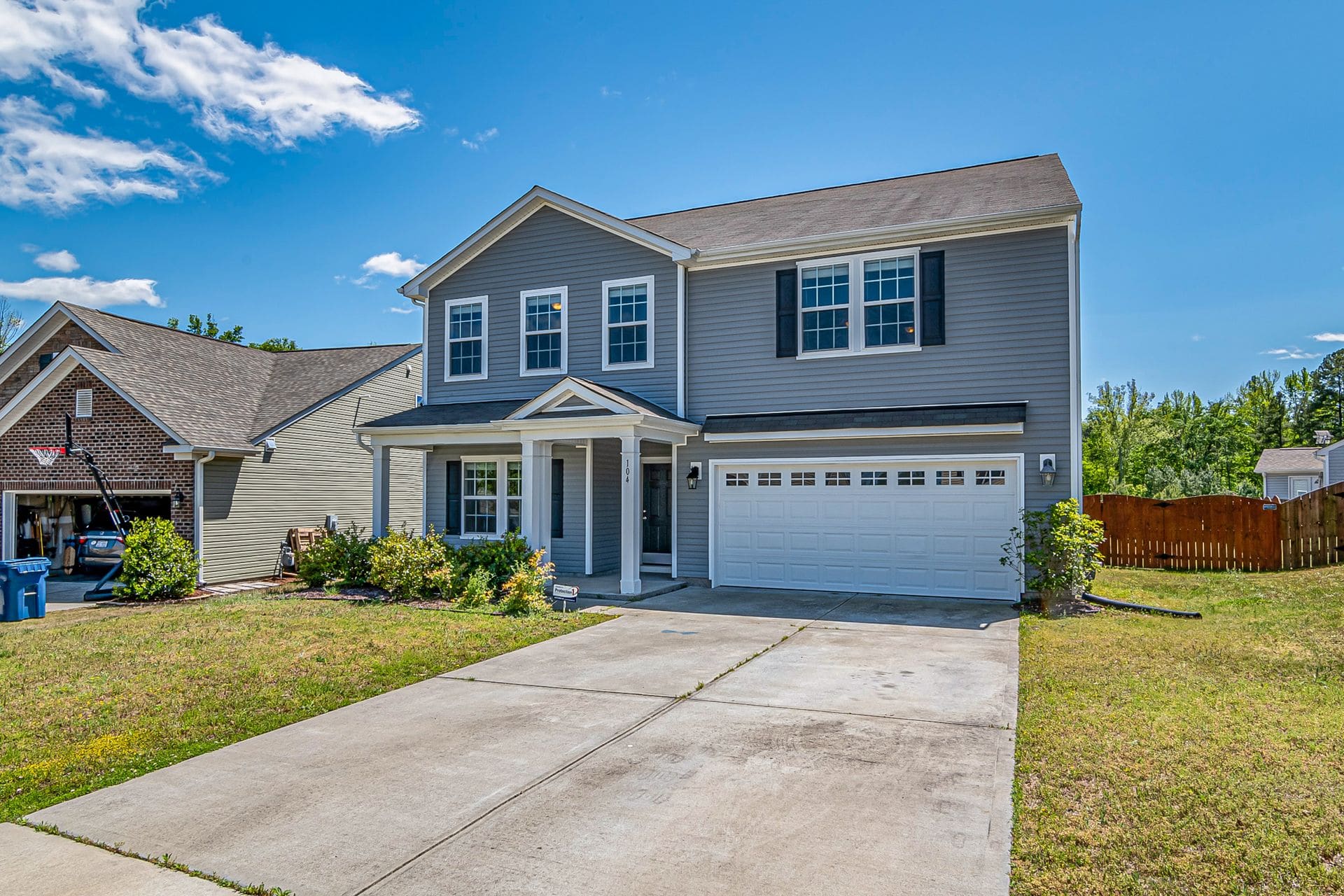 Wide concrete driveway in front of a two-story house